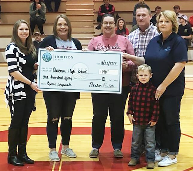 presents a check to the  Chrisman High School Booster Club